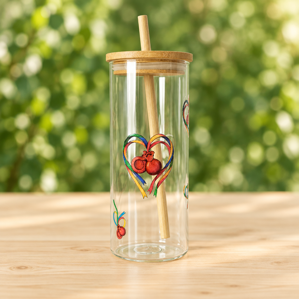 Vaso de cristal con pajita y dibujo de castañuelas maragatas sobre mesa de madera y fondo verde desenfocado