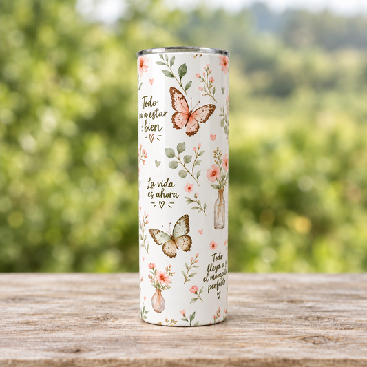 Segunda vista completa del vaso tumbler con mariposas sobre mesa de madera y fondo verde