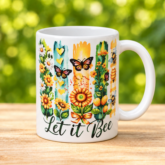 Taza Let it bee con flores, mariposas y abejas, asa a la derecha, sobre madera clara y fondo verde